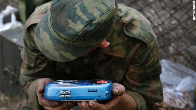 A pro-Russian rebel listens to the news on a transistor radio in the town of Novoazovsk, Ukraine, on Friday, August 29.