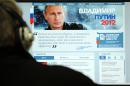 A man looks at a computer monitor displaying the main page of Russian Prime Minister Vladimir Putin's election campaign website, Moscow on January 12, 2012