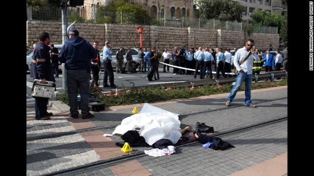 The body of a Palestinian attacker lies covered on the rails at a Jerusalem light train station on Wednesday, November 5. A police spokeswoman said the man was shot and killed after he deliberately rammed his vehicle into a crowd of pedestrians, then got out of the vehicle and attacked people with a metal bar. One pedestrian, an Israeli border police officer, was killed and 14 other people were injured.