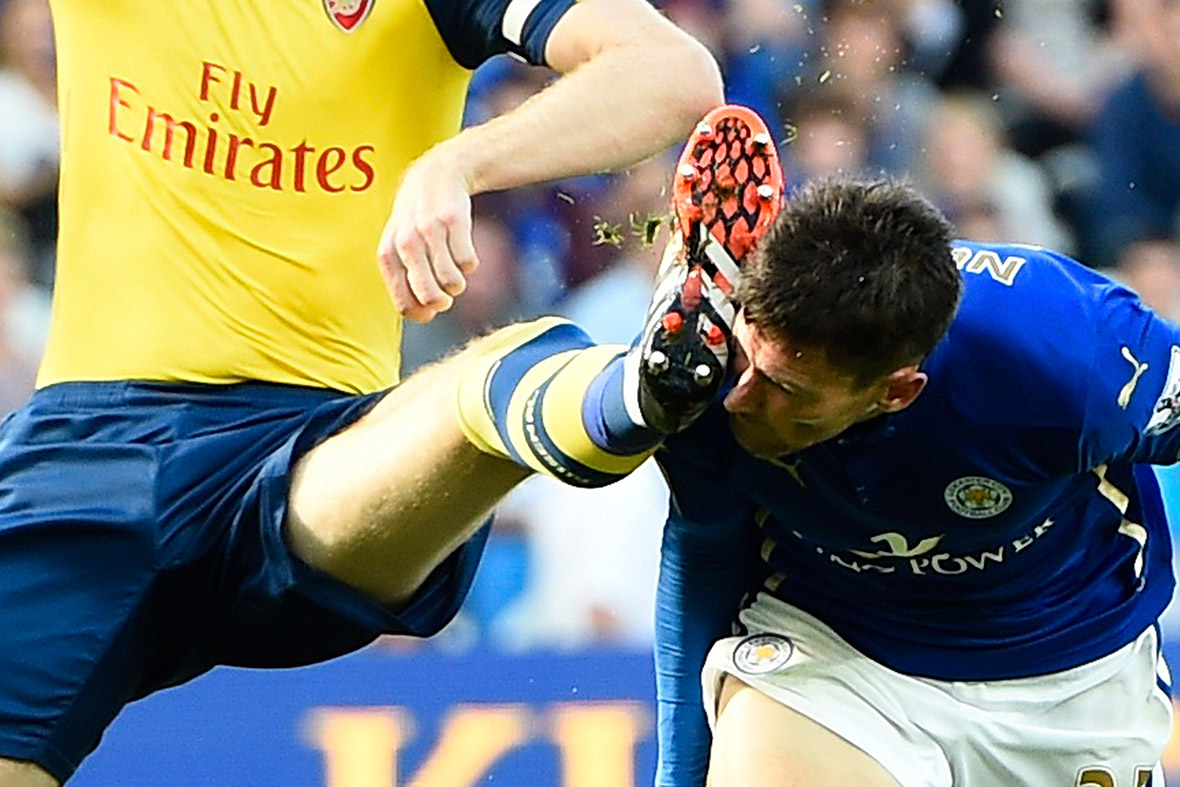 Arsenal's Per Mertesacker catches Leicester City's David Nugent in the face with his boot during their Premier League match at the King Power Stadium in Leicester
