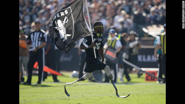 Olympic sprinter Blake Leeper carries an Oakland Raiders flag during the team's game against the Denver Broncos on Sunday, November 9, at O.co Coliseum in Oakland, California. The Broncos won 41-17.
