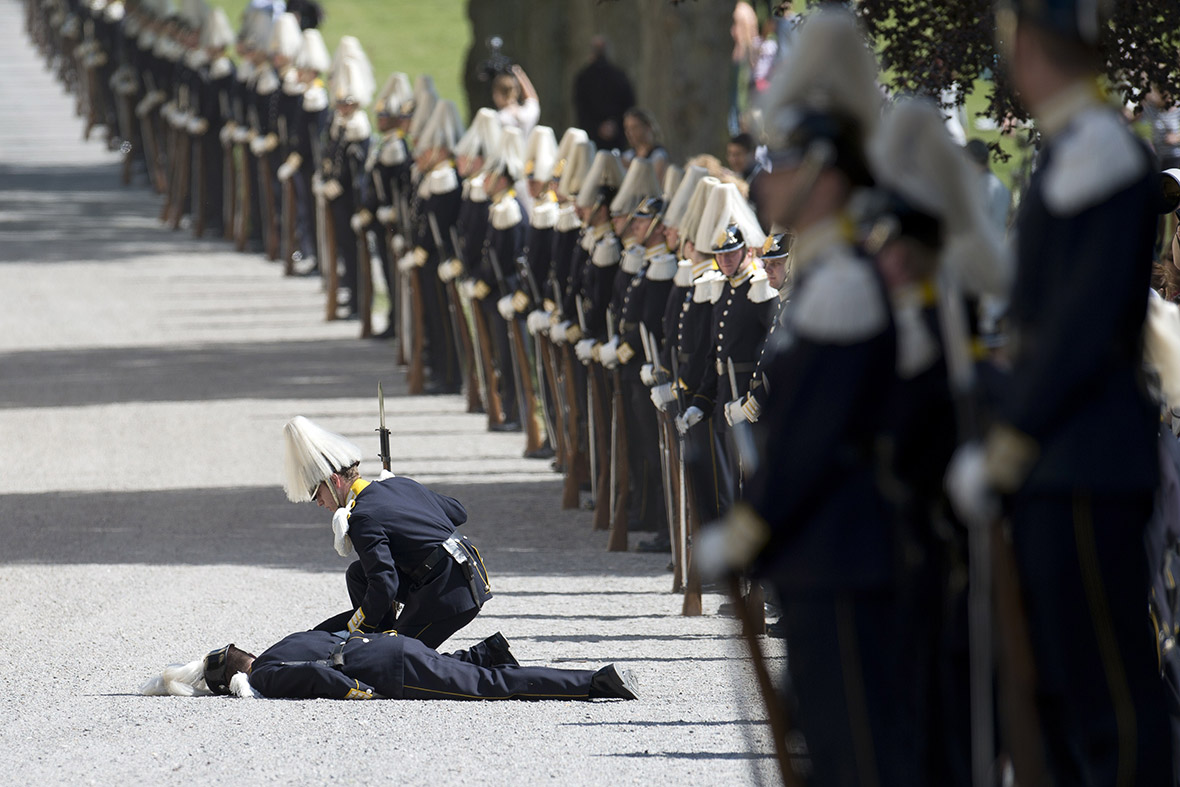 A soldier from the royal guard lies on the ground after fainting as guests were arriving for Princess Leonore's christening at the Royal Chapel in Drottningholm Palace near Stockholm