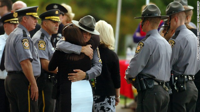 A woman embraces a Pennsylvania state trooper during the viewing of Dickson's body Wednesday, September 17, in Scranton.