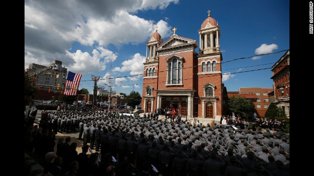An honor guard carries the casket of Cpl. Bryon K. Dickson, a Pennsylvania state trooper, from his funeral service Thursday, September 18, in Scranton, Pennsylvania. Dickson was one of <a href='http://ift.tt/1D8UK0t'>two state troopers shot last week</a> while they were leaving their police barracks in Blooming Grove, Pennsylvania. The other trooper, Alex T. Douglass, was severely wounded.