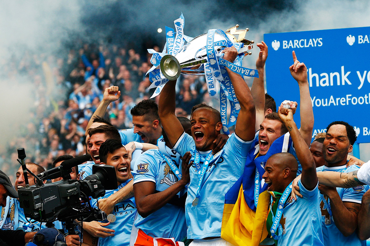Manchester City's captain Vincent Kompany celebrates with the English Premier League trophy following their match against West Ham United at the Etihad Stadium in Manchester