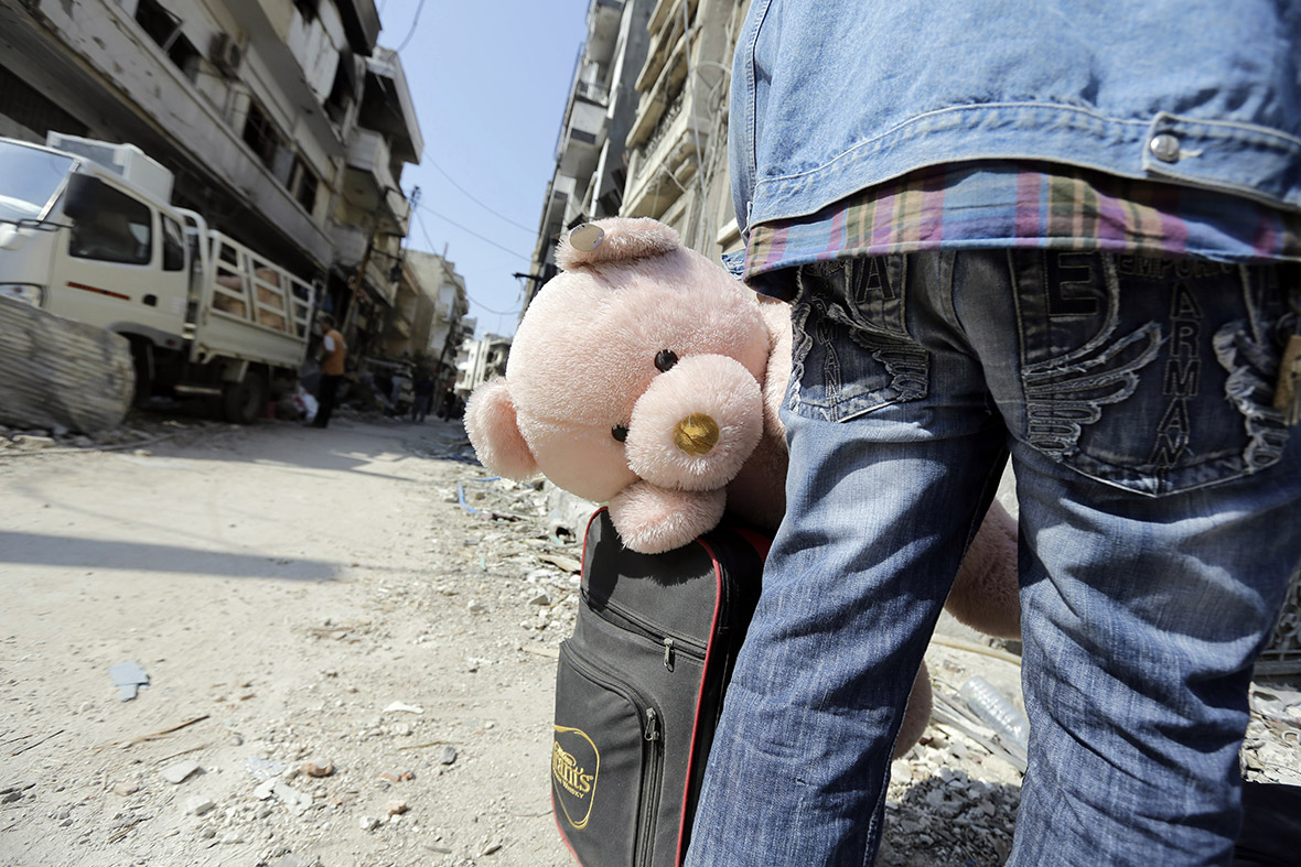 Residents of the Old City of Homs carry their belongings out from their neighbourhood