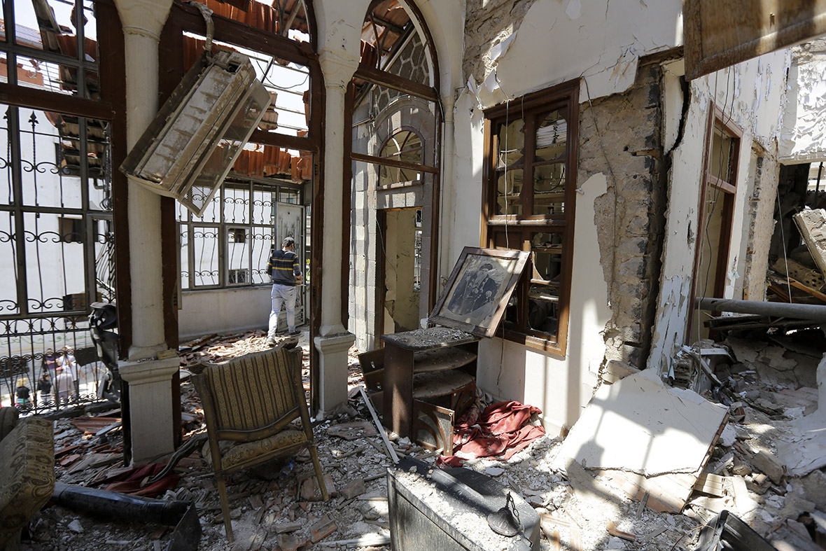 A man walks through a damaged building in the compound of the Syrian Orthodox Um al-Zinar church
