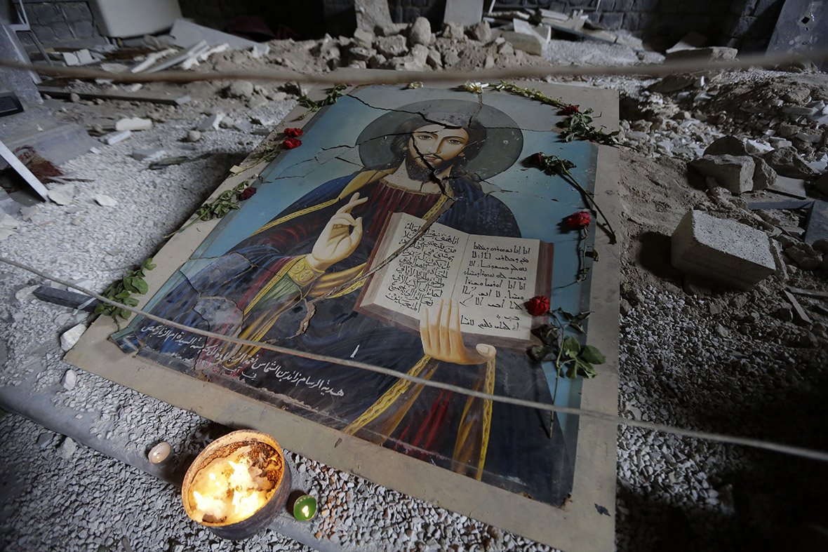 A damaged painting of Christ lies on the ground in the Syrian Orthodox Um al-Zinar church in the Christian Hamidiyeh neighbourhood