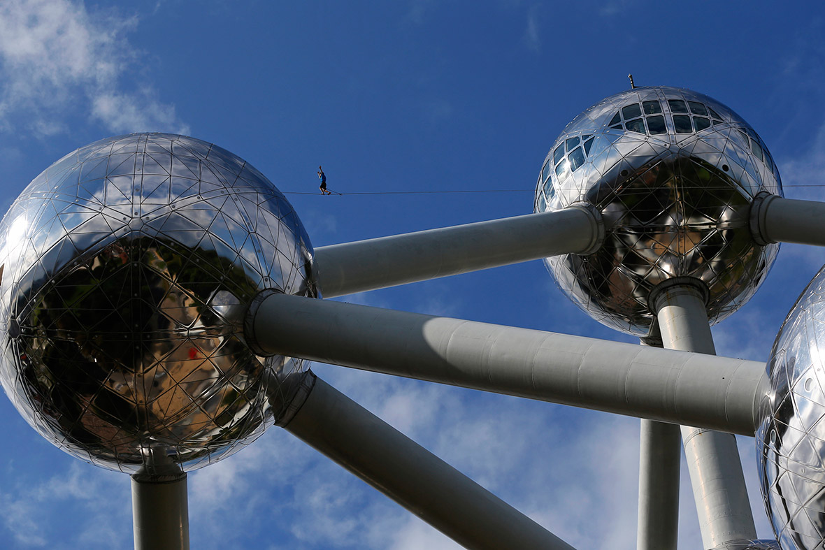 A tightrope walker performs between two spheres of the Atomium monument in Brussels