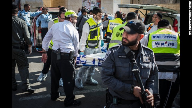 Israeli emergency personnel carry a body outside a synagogue on Tuesday, November 18, in the deadliest attack in Jerusalem in six years. Armed with knives and axes, two Palestinian men broke into the synagogue in the Har Nof area of western Jerusalem, killing four worshippers and wounding six others, Israeli police said.