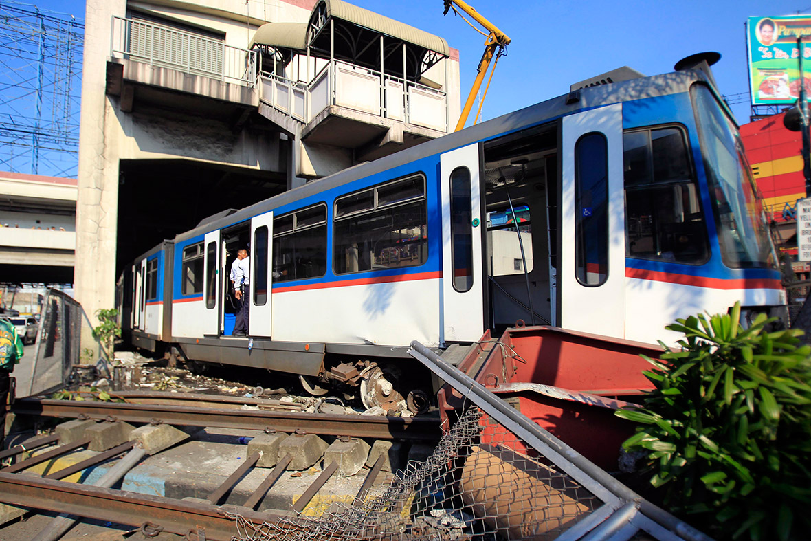 A security guard checks a coach of the Metro Rail Transit (MRT) for injured passengers after it derailed at the train station in Pasay city, metro Manila, Philippines