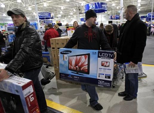 Matt Giardina carries his purchase, a HDTV, at a Best Buy store on the shopping day dubbed 'Black Friday' in Framingham, Massachusetts November 25, 2011. REUTERS/Adam Hunger