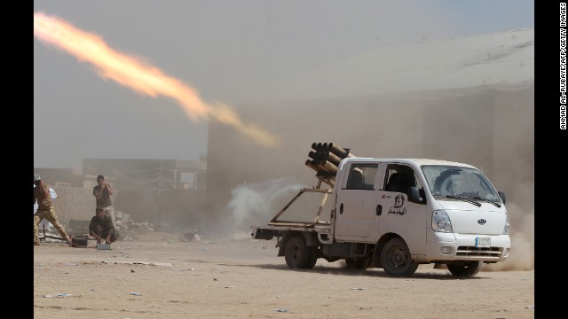 Iraqi Shiite militia fighters fire a rocket toward ISIS positions outside Tikrit, Iraq, on Wednesday, September 3. 
