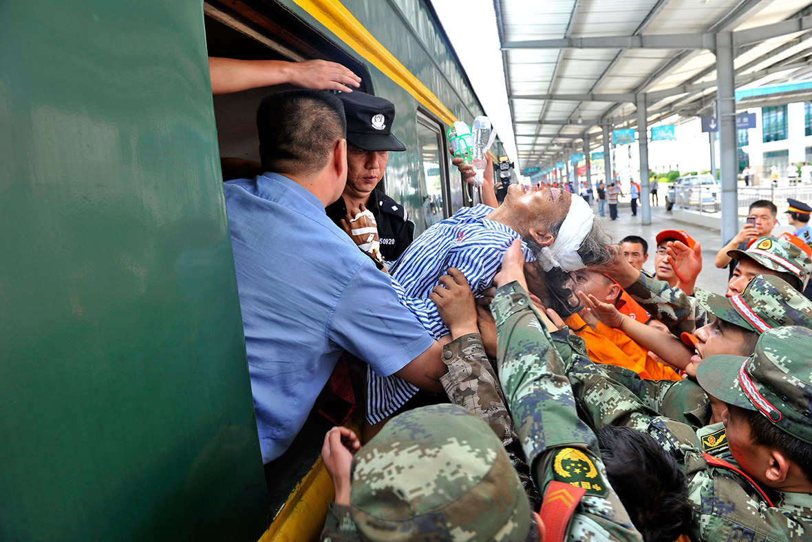 A severely injured person is carried through a window onto a train heading to Kunming to receive better medical treatment