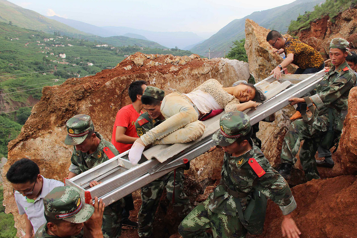 An injured woman is carried down a mountain on a ladder