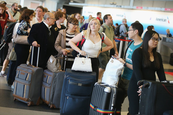 Passengers wait in line to reschedule flights at O'Hare International Airport on September 26, 2014 in Chicago, Illinois. All flights in and out of Chicago's O'Hare and Midway airports had been halted because of a suspected arson fire at a suburban Chicago air traffic control facility.
