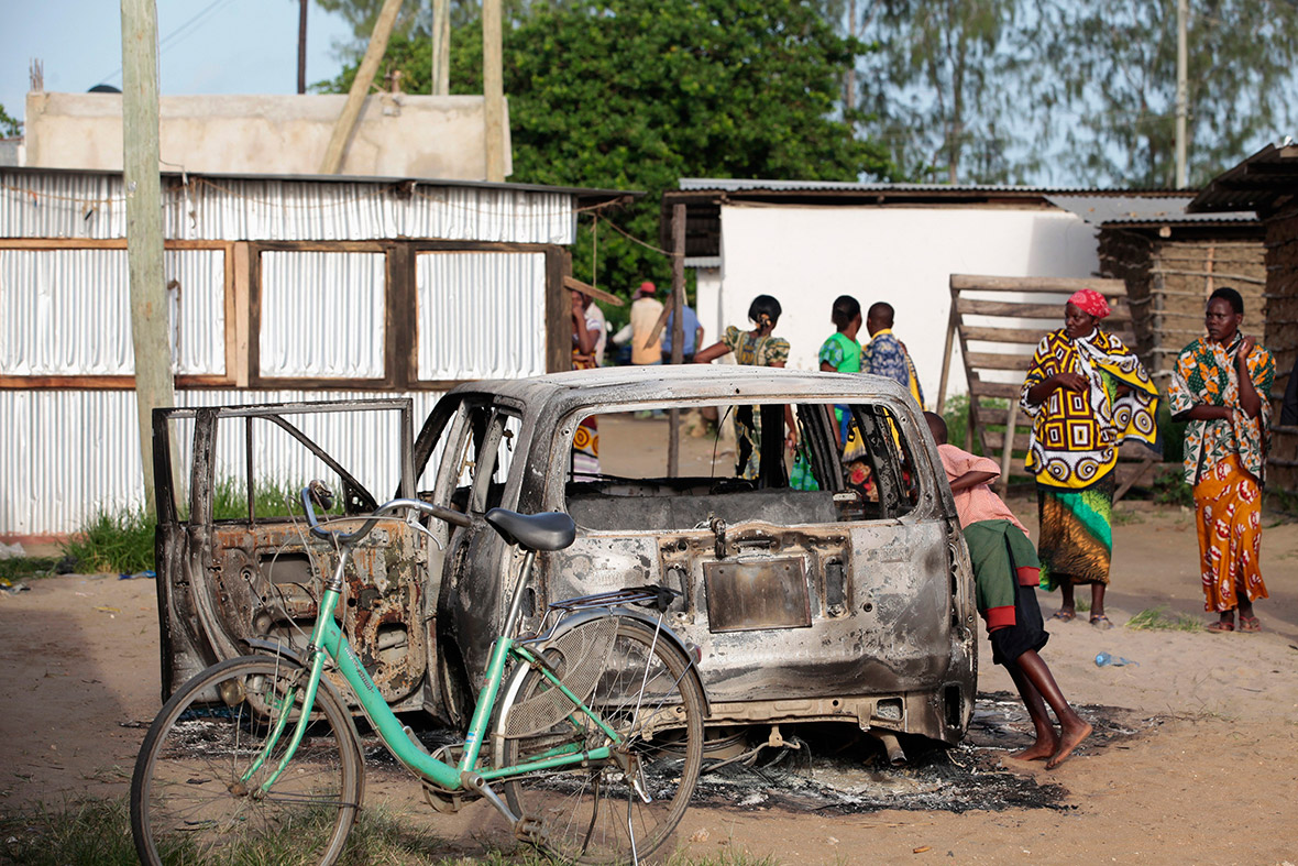 A boy peers into a burnt car after gunmen attacked the coastal Kenyan town of Mpeketoni. Somali-linked Islamists killed at least 50 people in the town, executing men in front of their families and killing others who had gathered to watch World Cup football on television