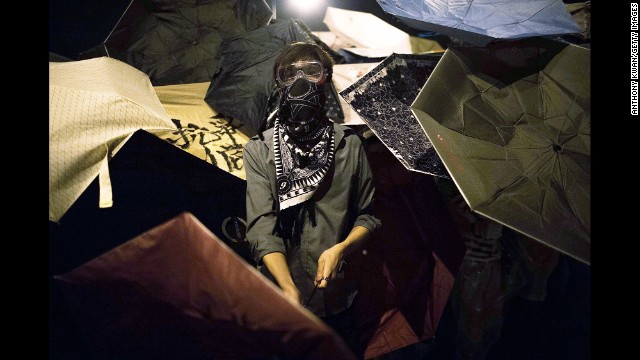 Pro-democracy protesters hide behind umbrellas to protect themselves from pepper spray on October 15.