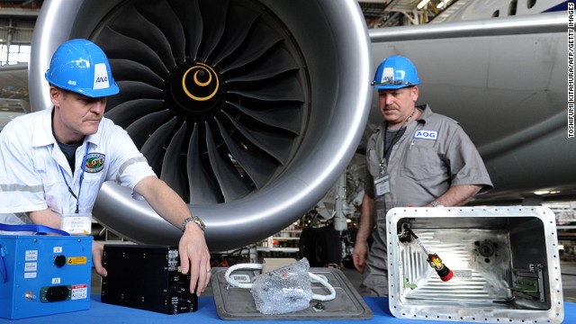 Members of Boeing's Aircraft On Ground (AOG) team display components of the new Dreamliner battery system after an ANA 787 test flight. To implement the fix, Boeing moved a small army of technicians to 13 international locations.