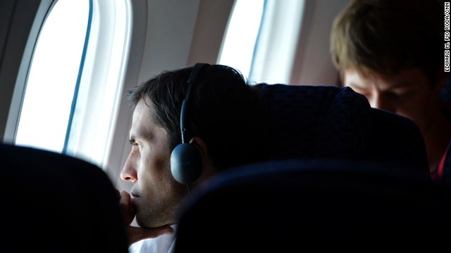 A passenger on United Airlines Flight 1 looks out one of the Dreamliner's oversized windows. The use of composite materials to build the airplane made larger window cutouts possible.