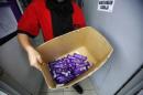 An employee shows a box containing Cadbury Dairy Milk Hazelnut and Cadbury Dairy Milk Roast Almond, to be return tomorrow in a shop in Shah Alam