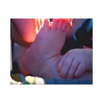 baby foot closeup with child hand holding canvas print