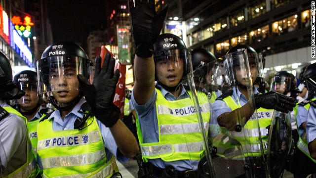 Police officers yell at pro-democracy protesters as they push forward in an attempt to clear a street on Saturday, October 18.