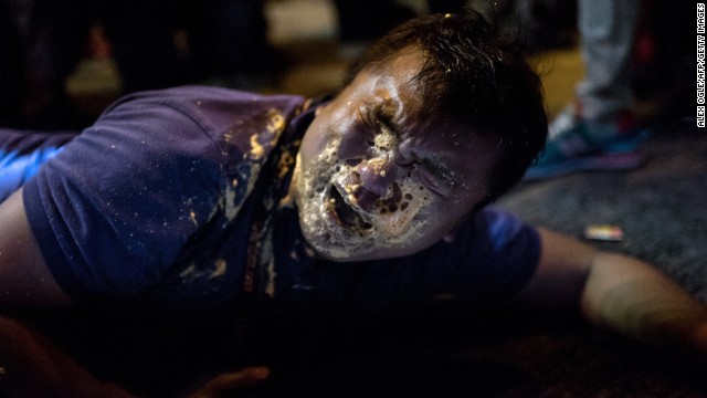 A Hong Kong journalist collapses in agony after being hit in the face with pepper spray during clashes with police on Friday, October 17. 