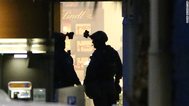 Two armed police officers stand ready to enter the cafe on December 16.