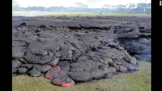 The horizontal incandescent cracks seen in the center and right portions of the photo, taken October 25, indicate that the flow was inflating: Fed by a continuing supply of lava beneath the cooling crust, the surface slowly rises.
