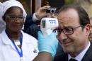 French President Hollande has his temperature measured upon his arrival at the Donka Hospital in Conakry