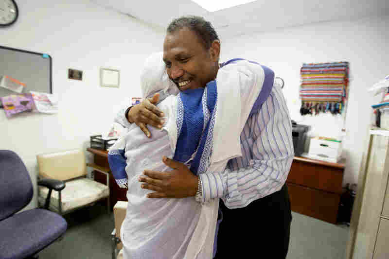Shekhey hugs Loba Tebemo Godiso after helping her and a friend at the Somali American Community Center. Many of the refugees Shekhey helps have spent years, even decades, in refugee camps before coming to the U.S. 