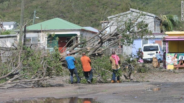 People clear trees from a road on the island of St. Martin in the aftermath of Hurricane Gonzalo.