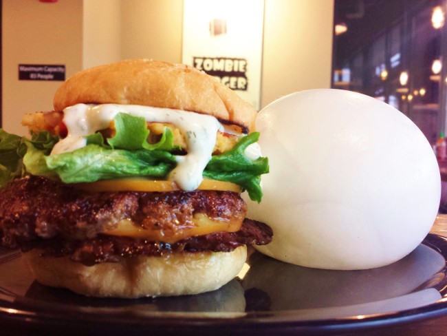 A local burger place is serving a burger with a mozzarella balloon on the side