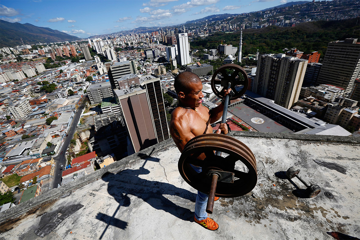 Gabriel Rivas, 30, lifts weights on a balcony on the 28th floor