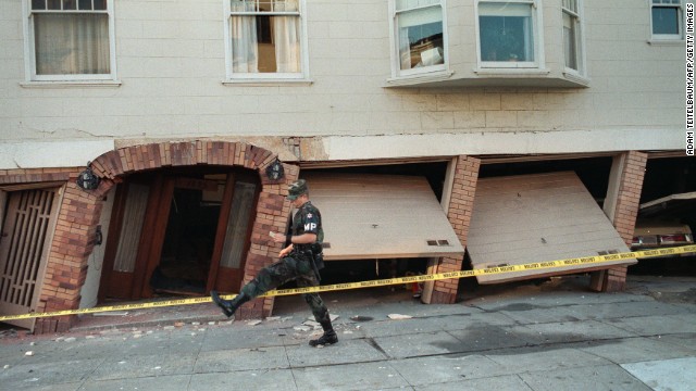 A military police officer steps over caution tape in the Marina District, one of the hardest-hit areas.