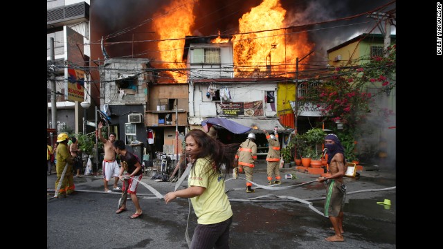 <strong>April 29:</strong> Residents help firefighters put out a blaze that engulfed a neighborhood in Manila, Philippines.