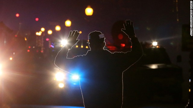 <strong>November 24:</strong> A protester in Ferguson, Missouri, stands in front of police vehicles with his hands up. A grand jury's decision not to indict police officer Darren Wilson for the killing of Michael Brown prompted <a href='http://ift.tt/1znoiDQ'>new waves of protests in Ferguson</a> and across the country.