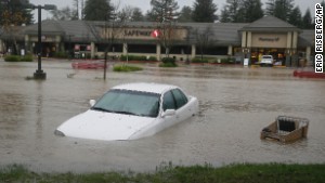A car and shopping cart are submerged in water at a shopping center Thursday in Healdsburg, California.