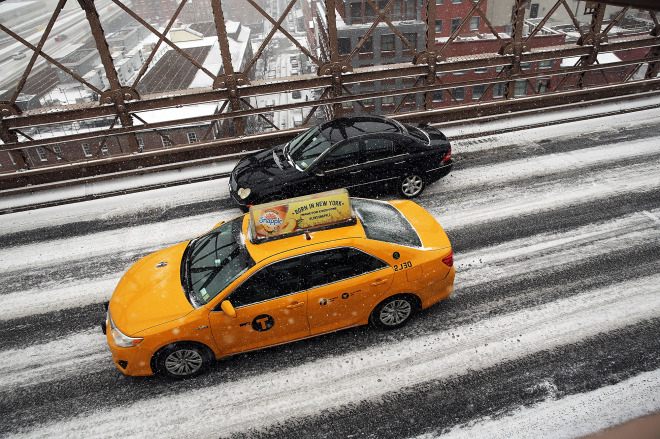 Cars drive on a Manhattan Street in heavy snow on January 26, 2015 in New York City.