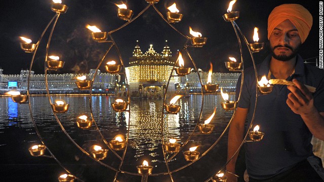 An Indian Sikh devotee lights candles at the illuminated Golden Temple in Amritsar. Though the three faiths celebrate Diwali -- the name comes from the word Deepavali, meaning "row of lights" -- in different ways, the main theme symbolizes the victory of good over evil and light over darkness.