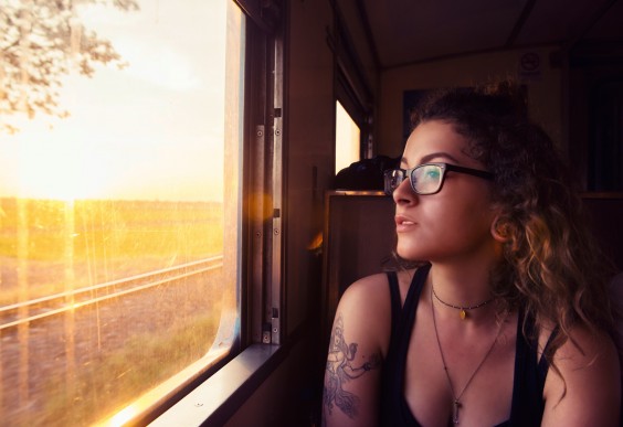 Minimalist Living: young woman looking out of train window