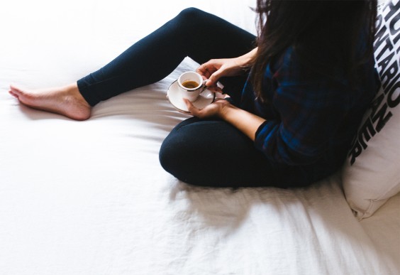 Woman Sitting in Bed With Coffee