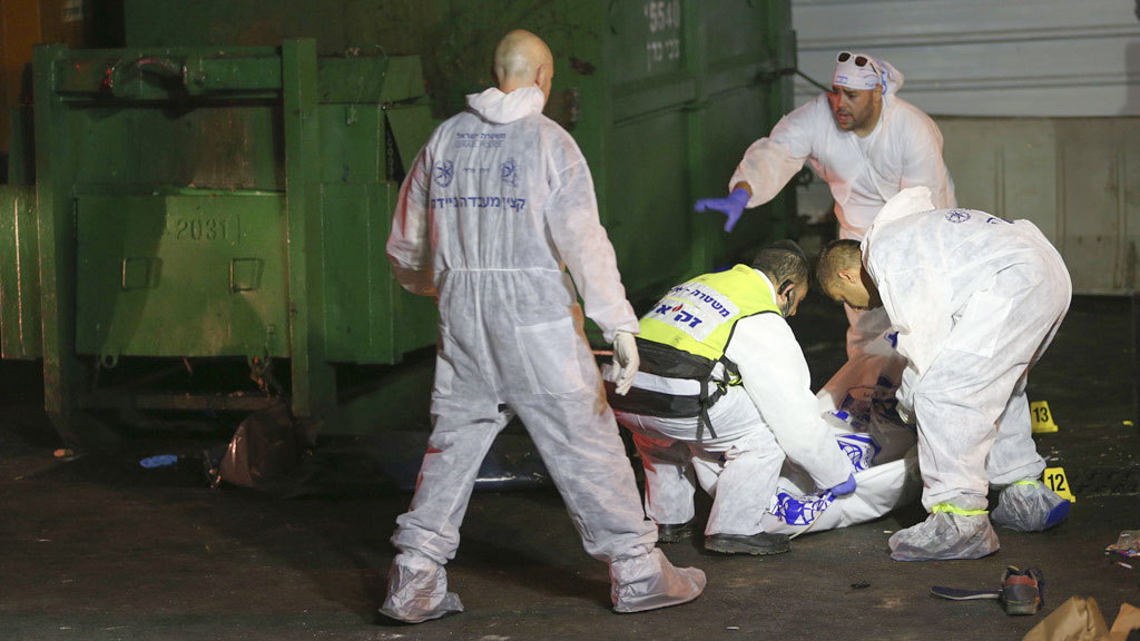 Ein Team israelischer Forensiker mit der in einen Sack gehüllten Leiche des palästinensischen Attentäters von Netanya.  | Bildquelle: AP