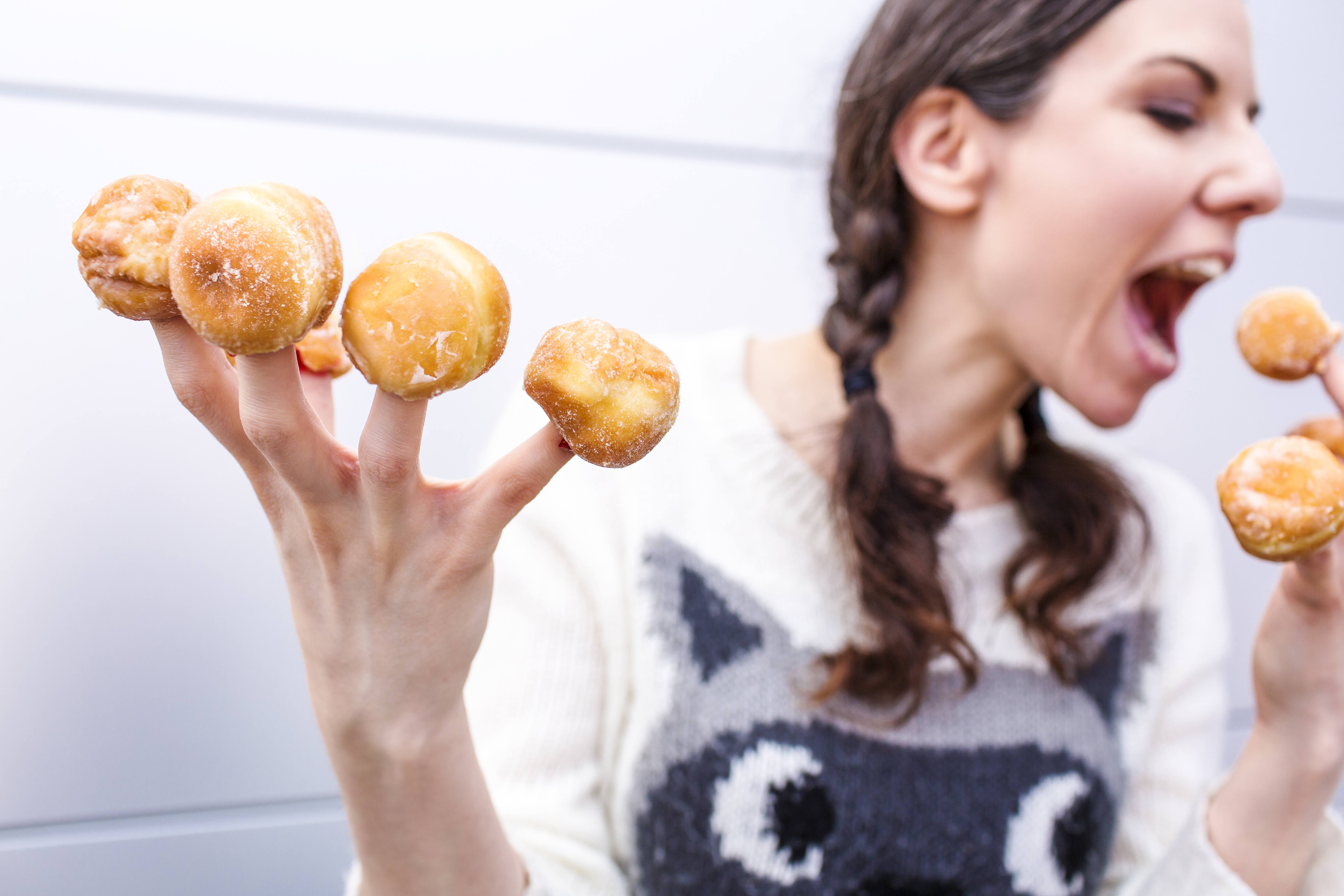 woman with donut on each finger