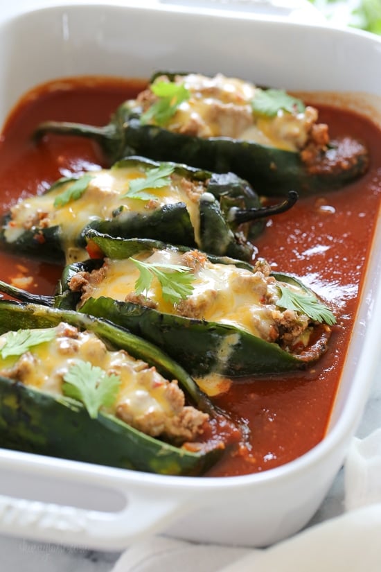 These baked Turkey Enchilada Stuffed Poblanos Rellenos are stuffed with a flavorful ground turkey filling, topped with my homemade enchilada sauce and cheese. These are so much lighter than restaurant chile rellenos which are typically battered in egg and deep fried.