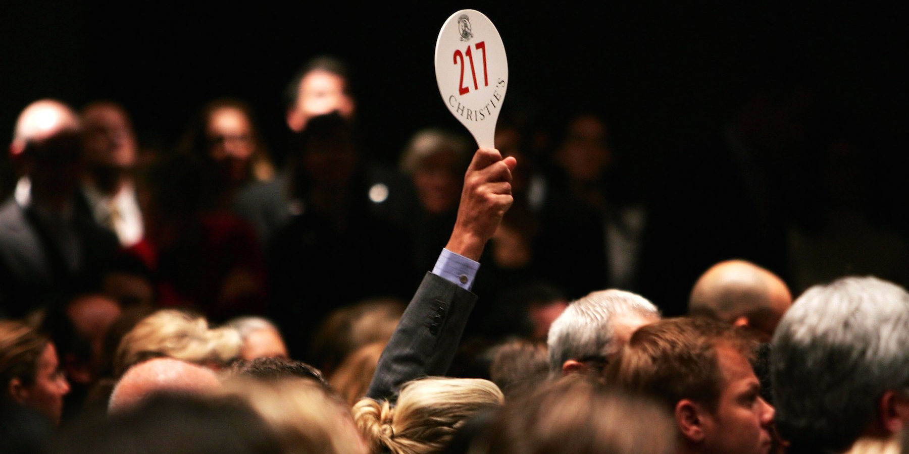 A man holds his hand up while bidding on a work of art inside the auction house Christie's during the Post-War and contemporary Art sale November 15, 2006 in New York City. Christie's estimates that works by Warhol, Willem de Kooning, Roy Lichtenstein and others could go for up to $220 million in what the auction house says may be the most valuable post-World War II and contemporary art auction in history. Warhol's 'Mao' portrait from 1972 went for over 17 million, setting an all time record for the artist. (Photo by )