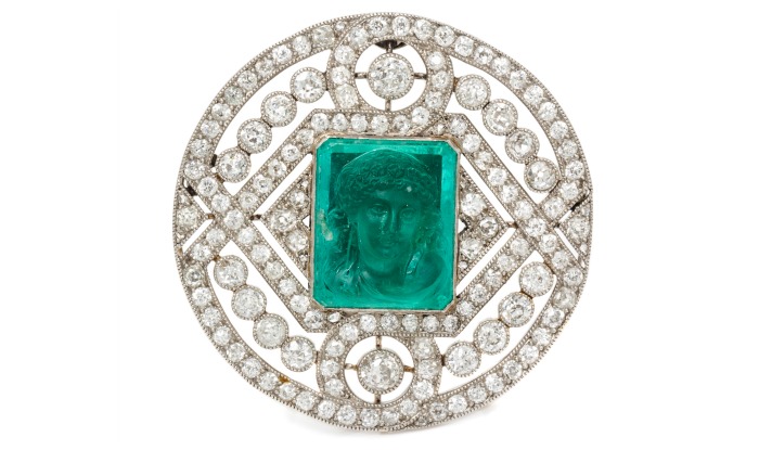 A Platinum, Diamond and Emerald Cameo Brooch, with a classical female profile depicted on a step-cut emerald.
