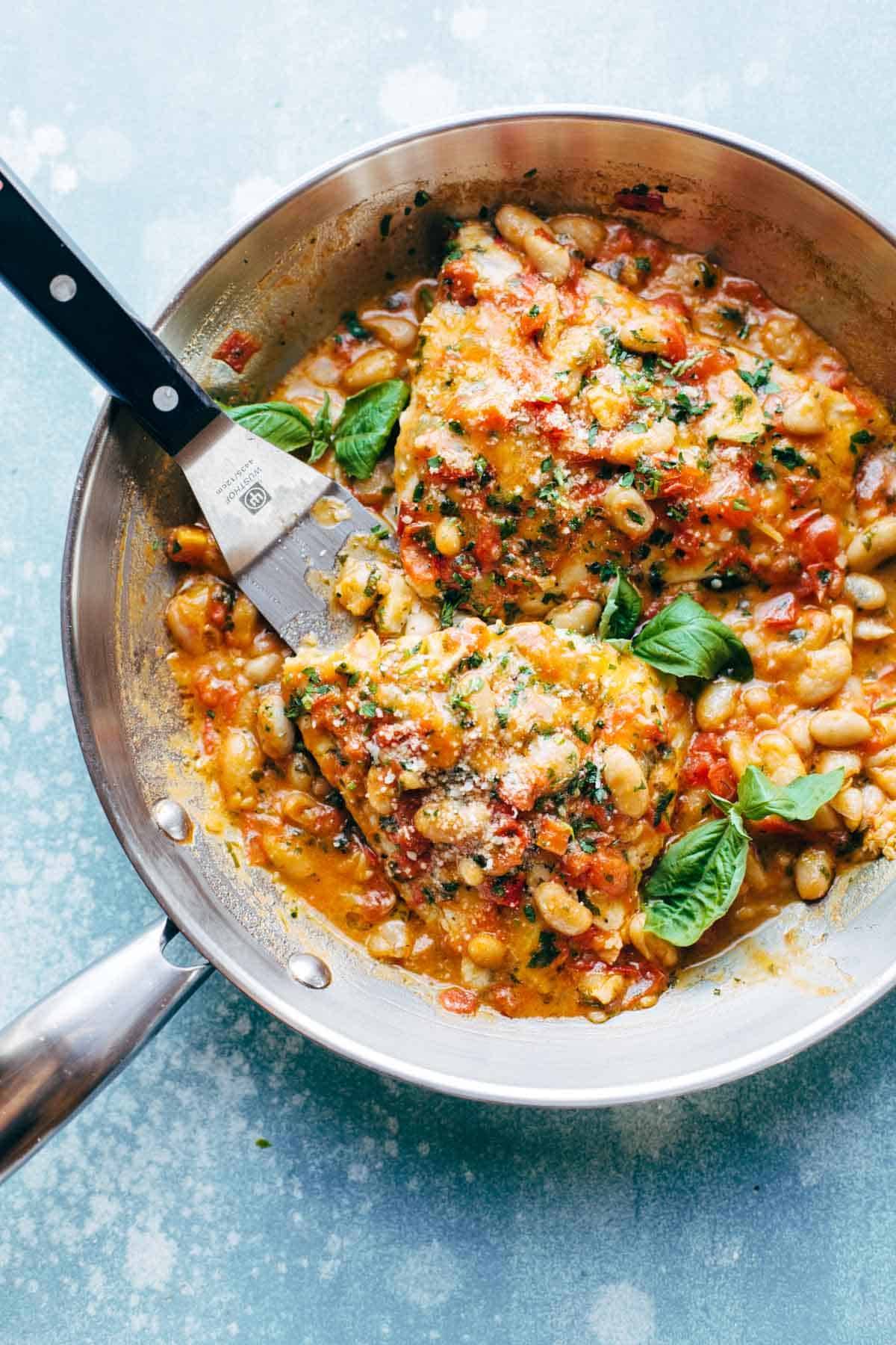 Garlic Basil Barramundi Skillet with Tomato Butter Sauce! SO YUMMY and super easy, with basic ingredients like garlic, basil, tomatoes, white beans, Parmesan, and white fish. Perfect with a green salad and crusty bread.. | pinchofyum.com