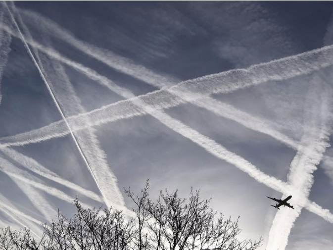  A passenger plane flies through aircraft contrails in the skies near Heathrow Airport in London, Britain, April 12, 2015. REUTERS/Toby Melville/File Photo